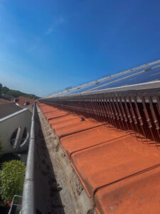 Abwehrspitzen entlang der Unterkante von Photovoltaikmodulen auf einem Ziegeldach